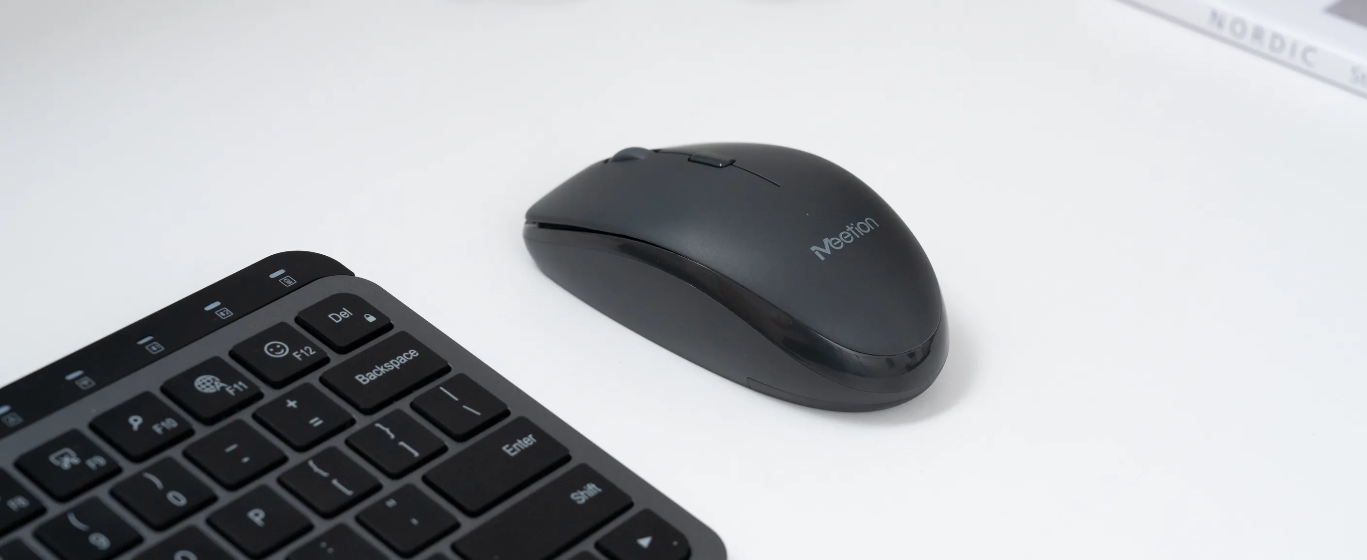 Meetion BTM100 wireless mouse on a white desk