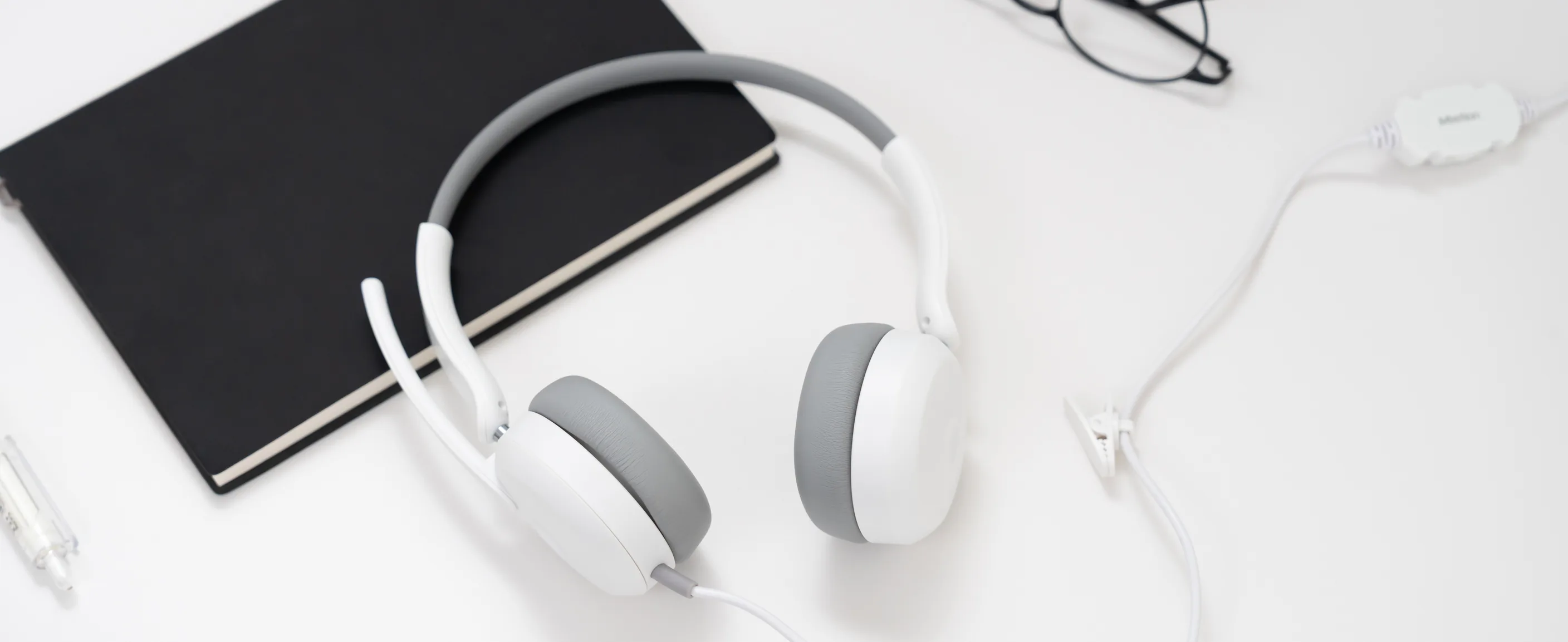 Meetion HP005U wired headset on a white desk with a notebook